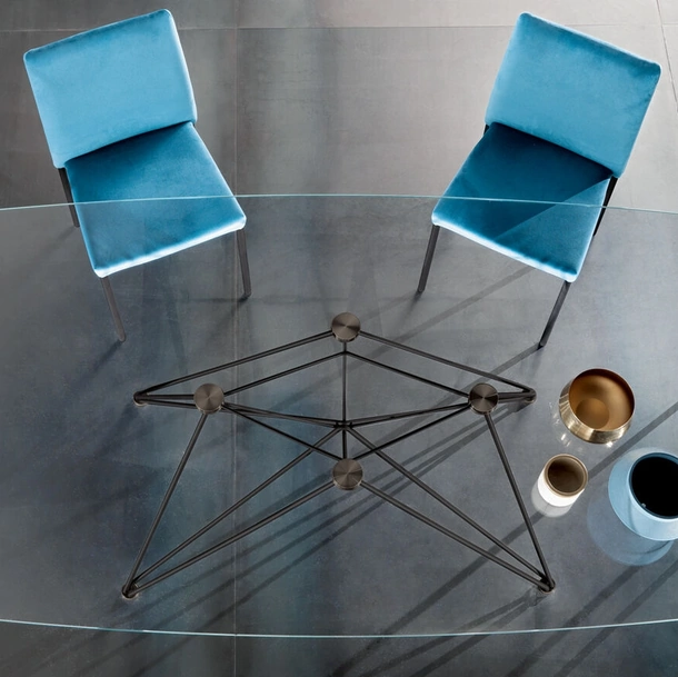 Tavolo Pegaso con piano in cristallo e base in tondino metallico di Riflessi